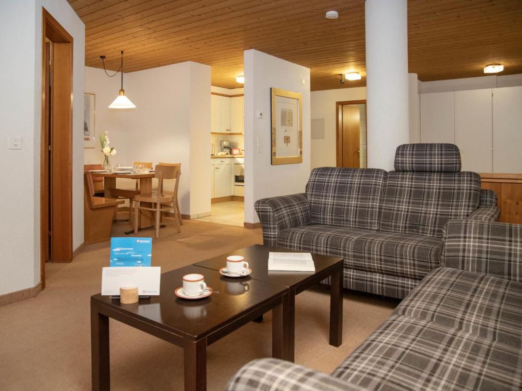 a living room with two couches and a table at Apartment Chalet Abendrot apARTments-17 by Interhome in Grindelwald