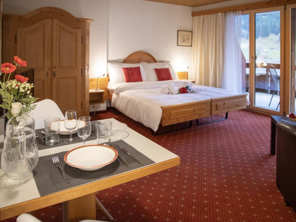 a hotel room with a bed and a table with plates on it at Apartment Chalet Abendrot apARTments-7 by Interhome in Grindelwald