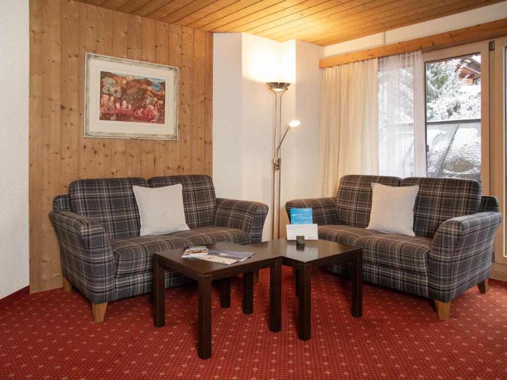 a living room with two chairs and a table at Apartment Chalet Abendrot apARTments-27 by Interhome in Grindelwald