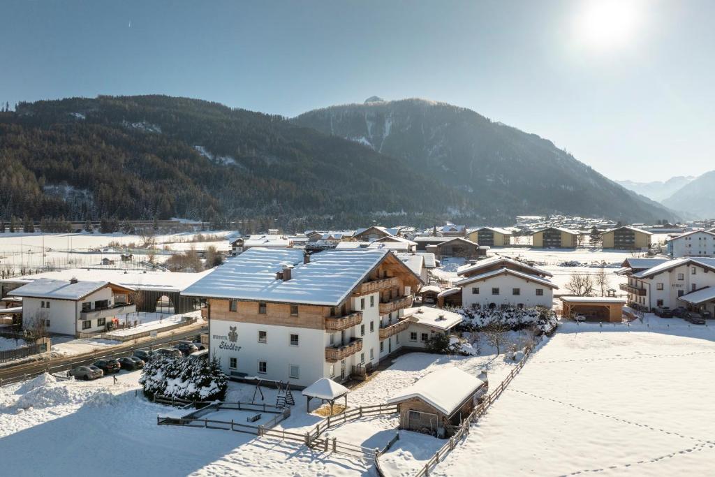 a town covered in snow with mountains in the background at Aparthotel Stadler in Flachau