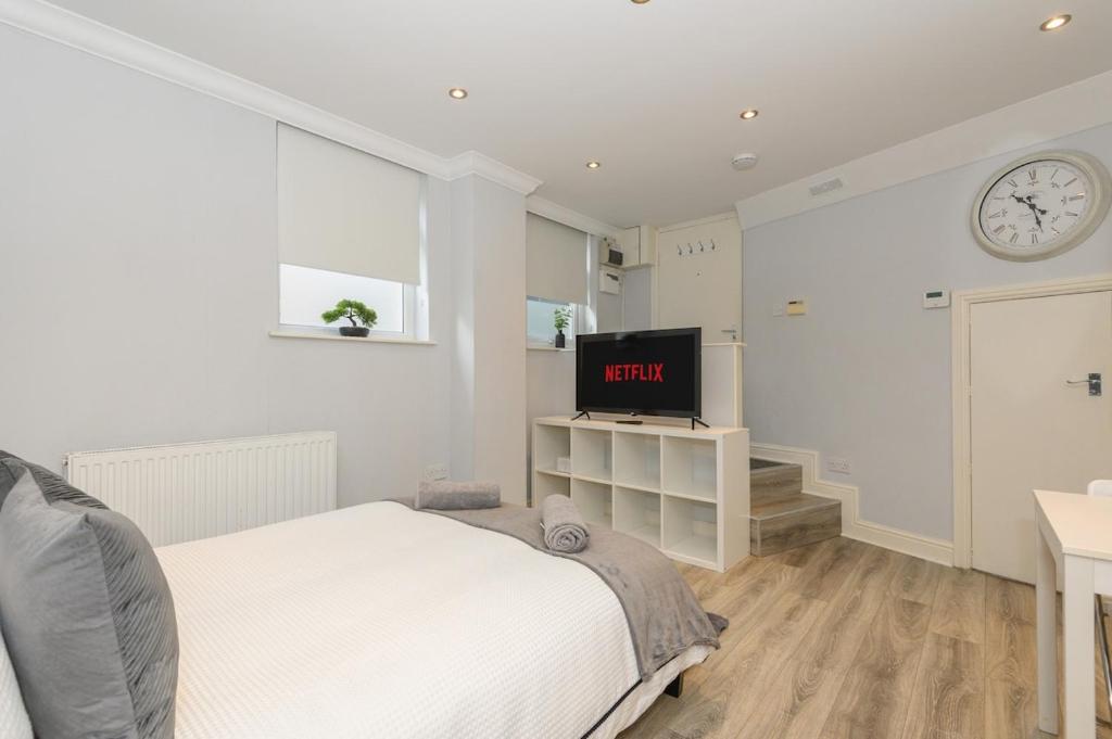 ein Schlafzimmer mit einem Bett und einem Fernseher an der Wand in der Unterkunft Boutique Flat In Huddersfield Town Centre in Huddersfield