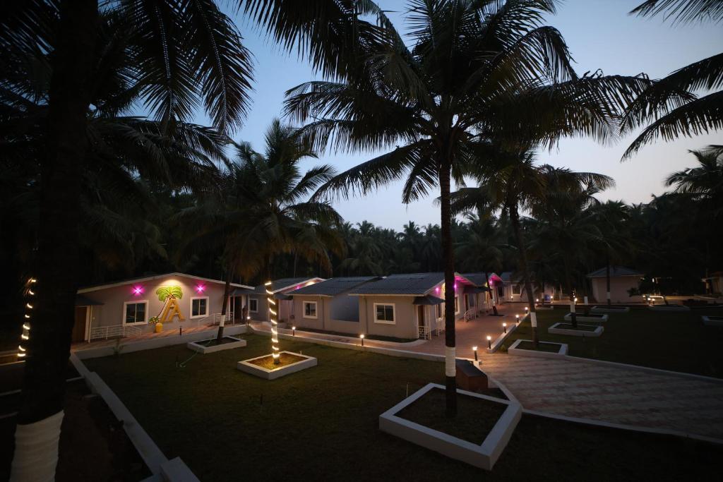 a resort with lights and palm trees at night at Aarna Coastal Resort in Māvalli