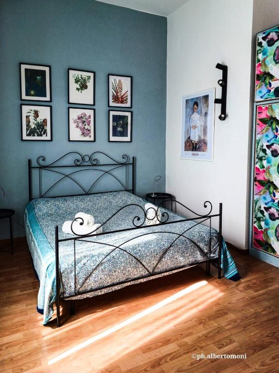 a bedroom with a bed with pictures on the wall at Al mare da Alfred and Cate - Ampio appartamento a due passi dal Centro Storico e dalla Stazione con AC in Piombino