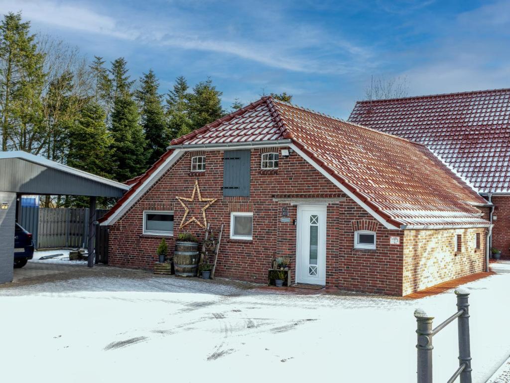 a red brick house with a star on it at Holiday Home An der Tanne by Interhome in Westerschoo
