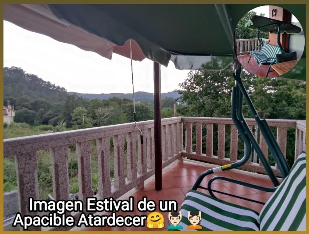een tuinhuisje met 2 stoelen en een parasol op een terras bij Eido da Consaca in Ponteareas