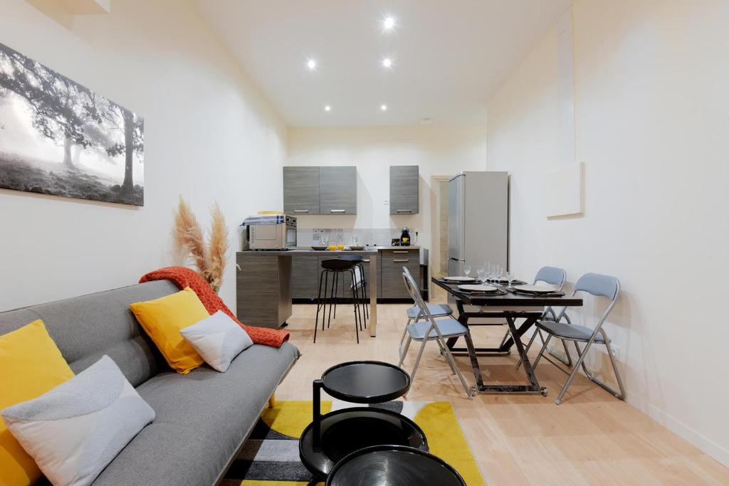 un salon avec un canapé et une table dans l'établissement L'Appart Chic - Terrasse - Proche Lyon & tram, à Villeurbanne