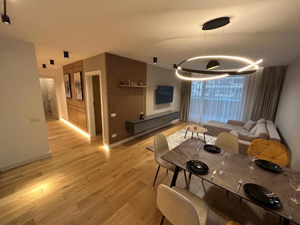 a living room with a table and chairs and a couch at B-Holiday Luxury Apartments Urban Plaza in Braşov