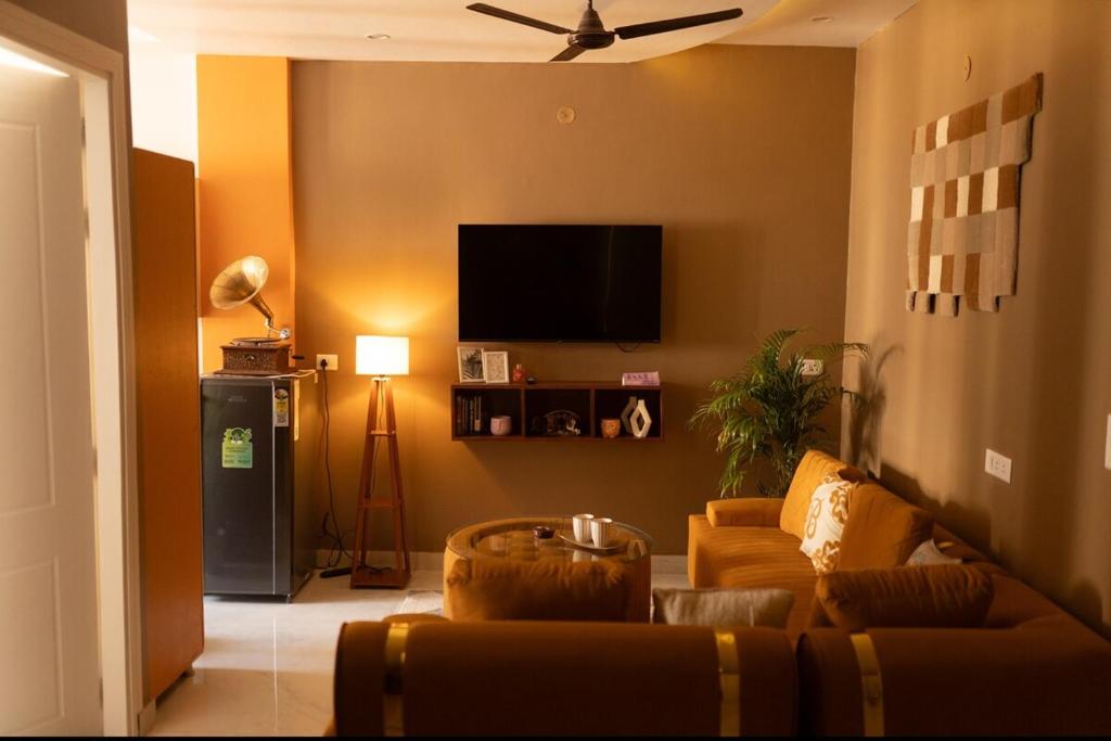 a living room with a couch and a flat screen tv at Mochastay in Dehradun