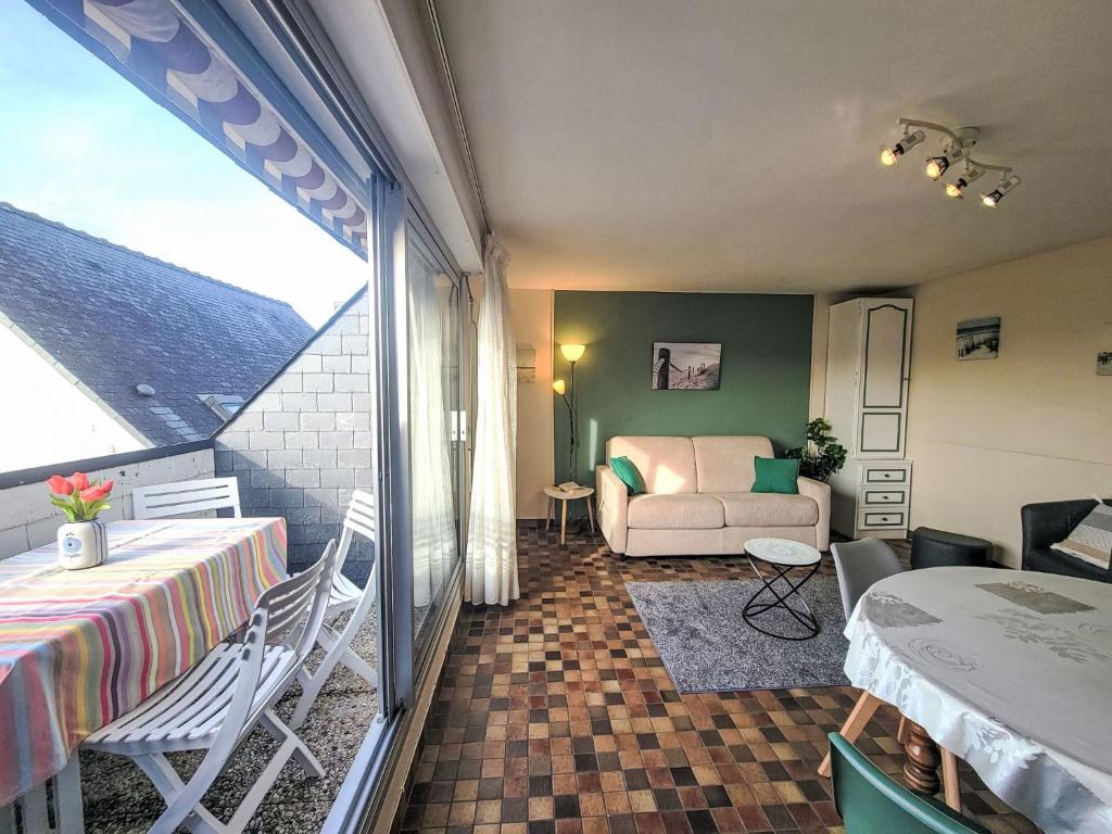 a room with a balcony with a table and a couch at Apartment Les Embruns-1 by Interhome in Carnac