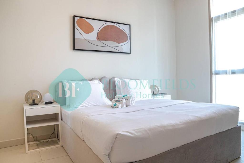 a bedroom with a large bed with a white bedspread at Bloomfields Stylish 1br In Reflections Al Reem in Mushayrib