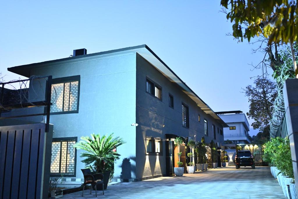 a blue building with chairs and plants on a street at Oslo Rezidor in Islamabad