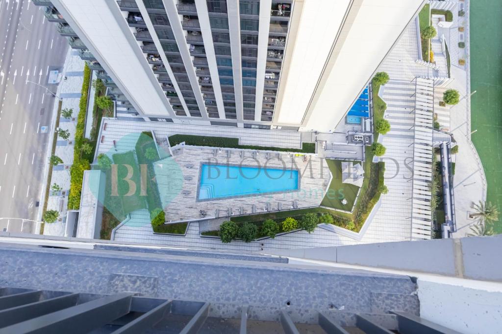 an overhead view of a building with a swimming pool at Bloomfields Metropolitan 3br In Bridges in Abu Dhabi