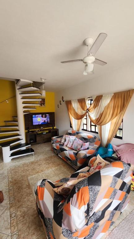 a living room with two beds and a flat screen tv at Recanto da praia in Bertioga