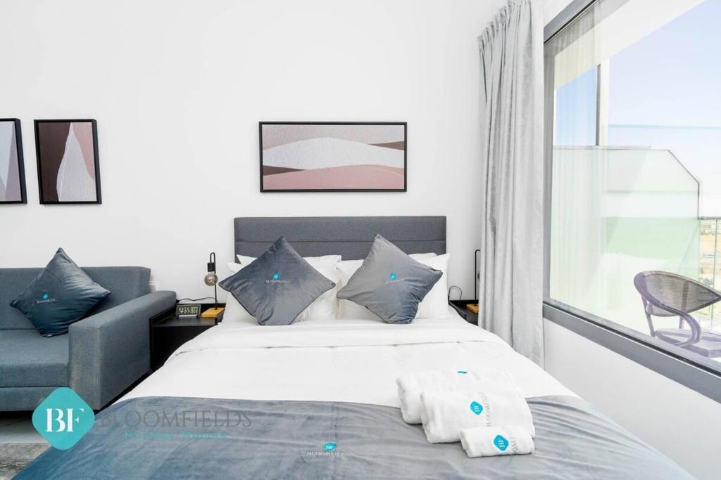 Un dormitorio con una cama blanca y una ventana. en Bloomfields Premium Stu In Oasis Masdar City, en Abu Dhabi Intl