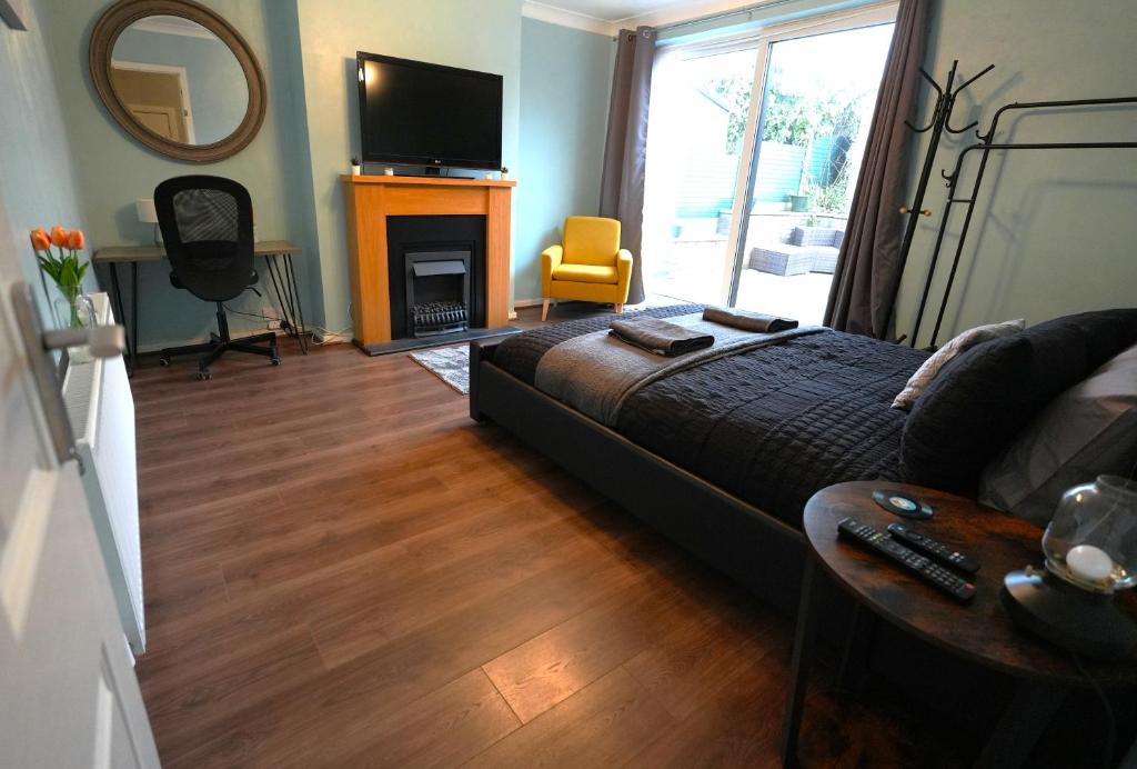 a bedroom with a bed and a fireplace and a television at Detached Homestay - Super, King & Double Rooms - Leyland, Preston, Chorley, Lancashire in Leyland
