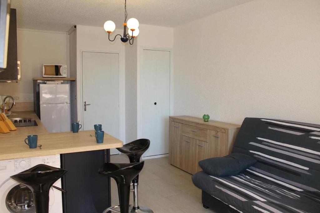 une cuisine avec une table, des chaises et un canapé dans l'établissement Appartement Studio Cabine - Gruissan GN050-489, à Gruissan