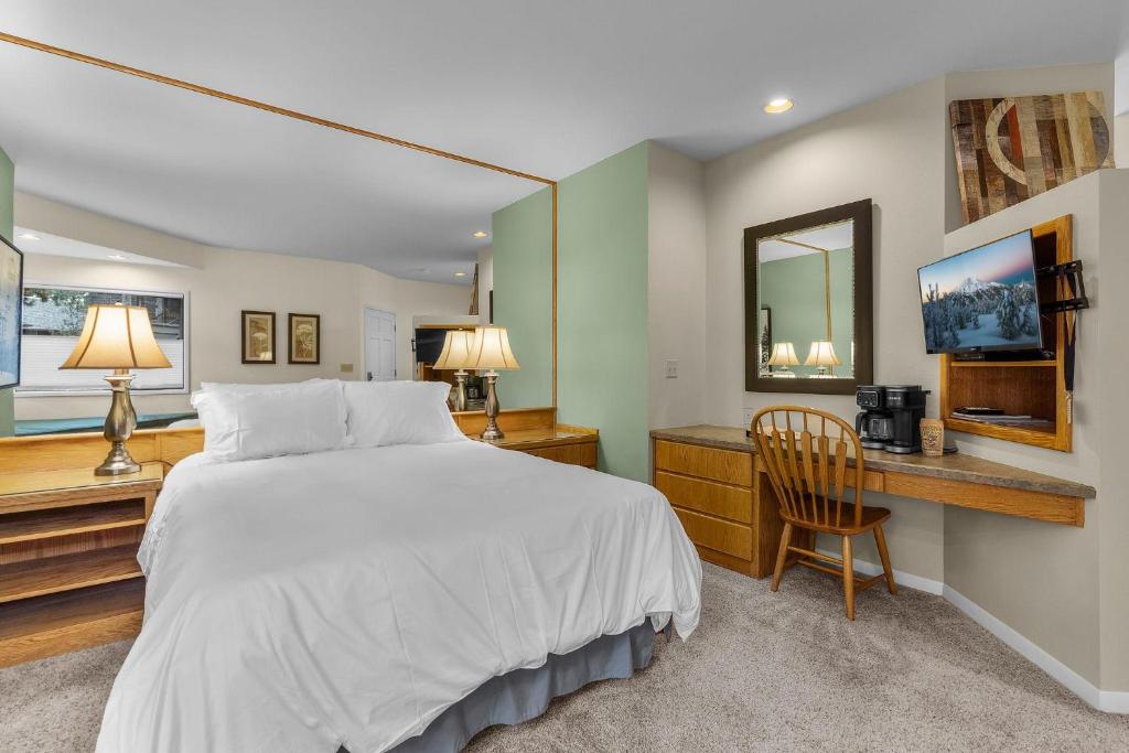 Un dormitorio con una cama, un escritorio y una silla. en Mt Bachelor Condo Queen Suite, en Bend
