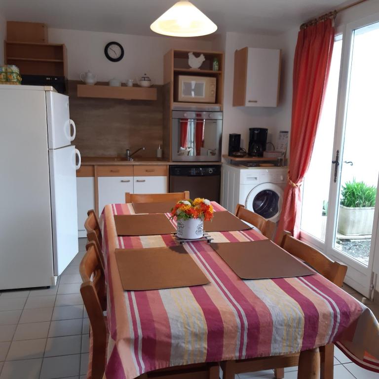 une cuisine avec une table recouverte d'une nappe dans l'établissement Gîte du Clos Bouillon, à Saint-Loup-Hors