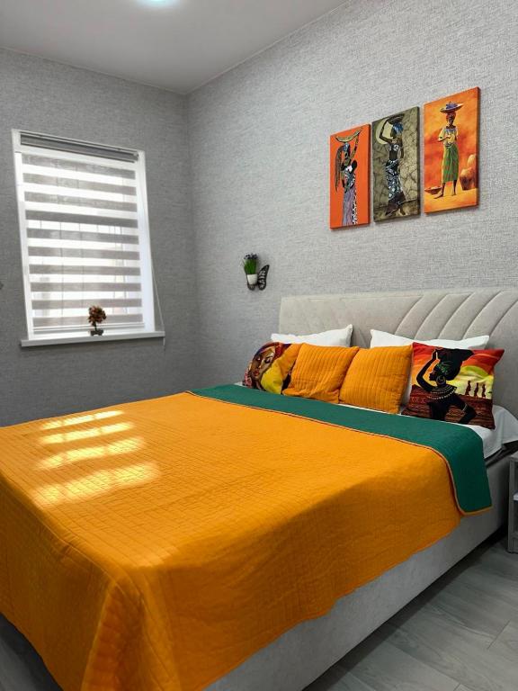 Un dormitorio con una cama grande con una manta naranja. en Old City Apartments, en Járkov