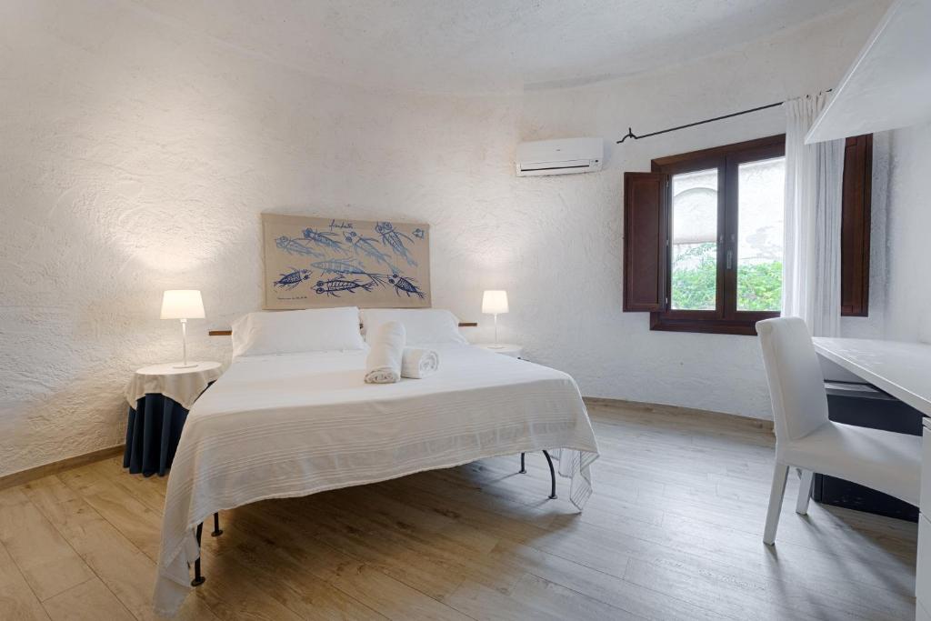 a white bedroom with a bed and a window at Hotel Villa Mediterranea in Noto Marina