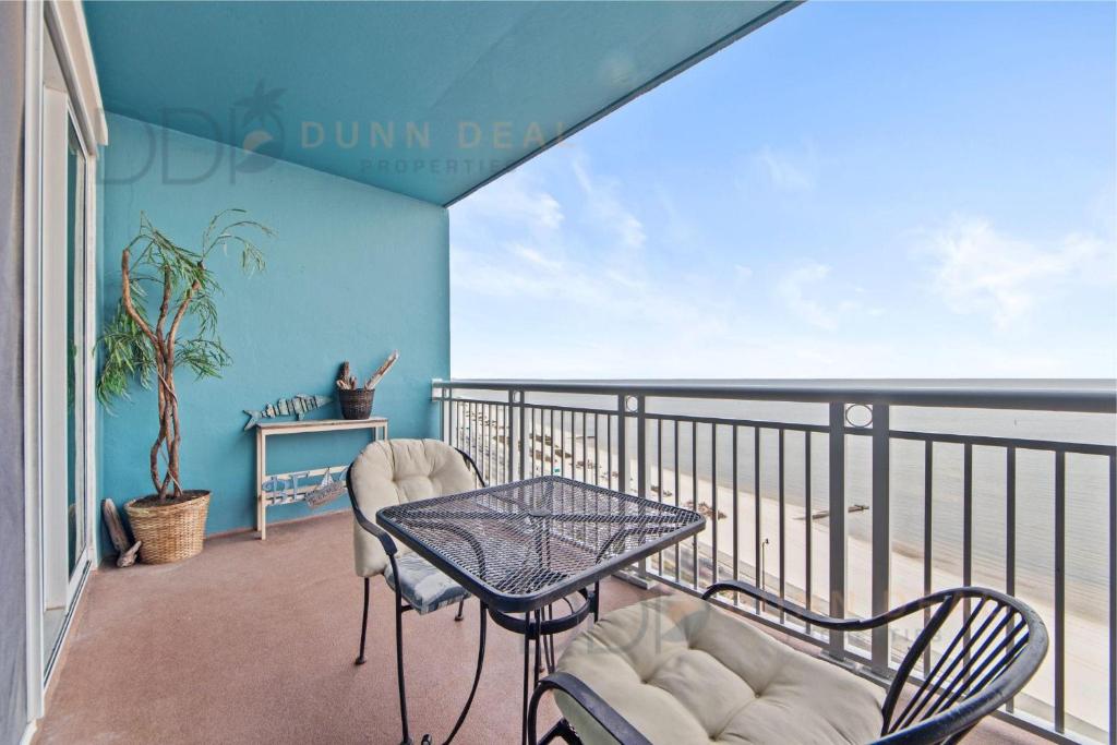 a balcony with a table and chairs and a view of the beach at Legacy Tower Two 1202 Deluxe in Gulfport