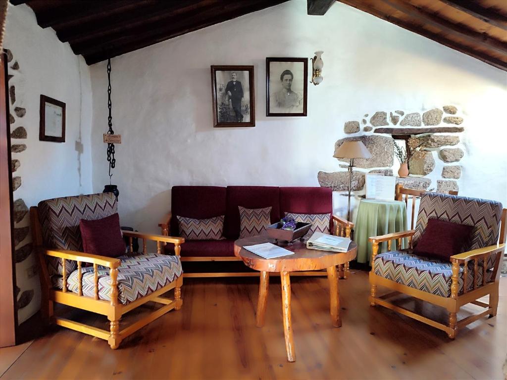 a living room with a couch and a table and chairs at Casa do Forno in Valezim