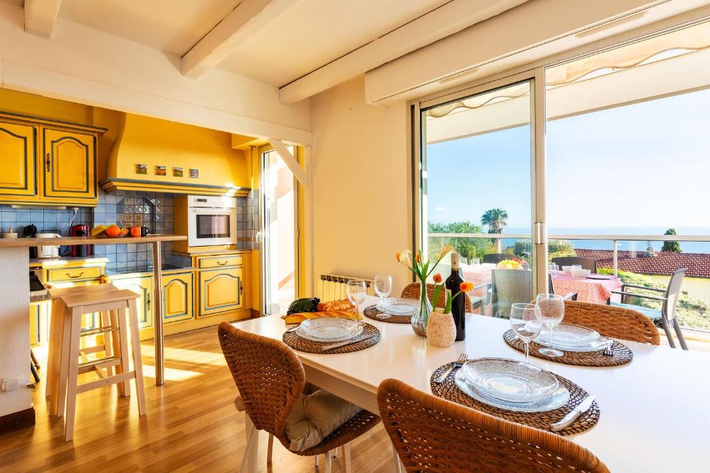 une salle à manger avec une table et des chaises et une cuisine dans l'établissement LE JARDIN BLEU AP4388 By Riviera Holiday Homes, à Nice