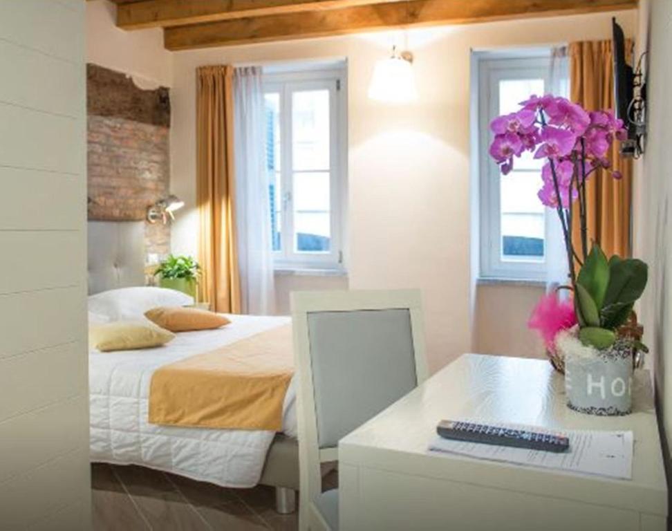 a bedroom with a bed and a desk with a computer at La Corte Fiorita Como in Como