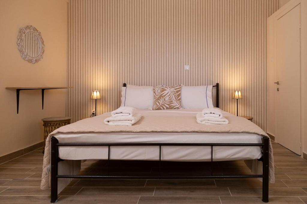 a bedroom with a large bed with two towels on it at Poseidon Apartments and Villas by the Sea in Sounio