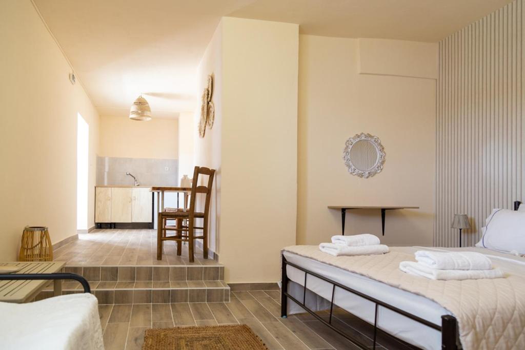 a bedroom with a bed and a dining room at Poseidon Apartments and Villas by the Sea in Sounio