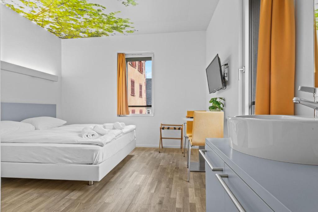 Postel nebo postele na pokoji v ubytování Hôtel de la Poste Sierre