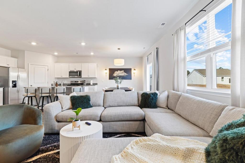 Scotts HillにあるLuxury 5BR Home Near Beaches & Downtown Wilmingtonのソファとキッチンのあるリビングルーム