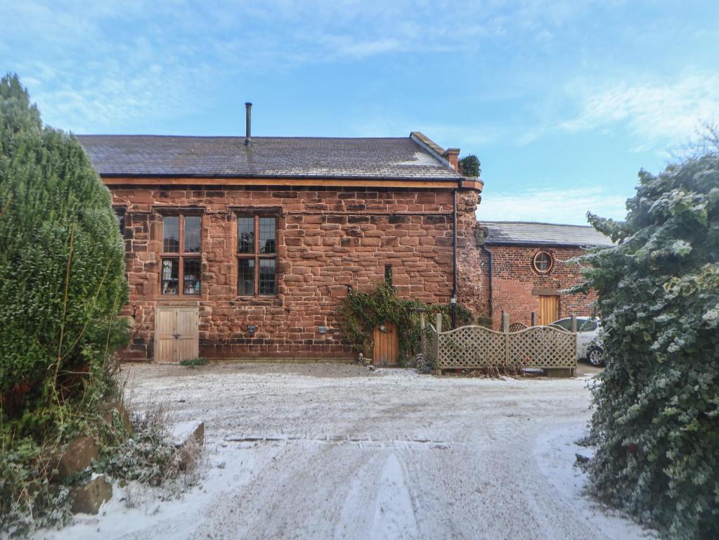 a brick house with two benches in front of it at Monastery Hall in Chester
