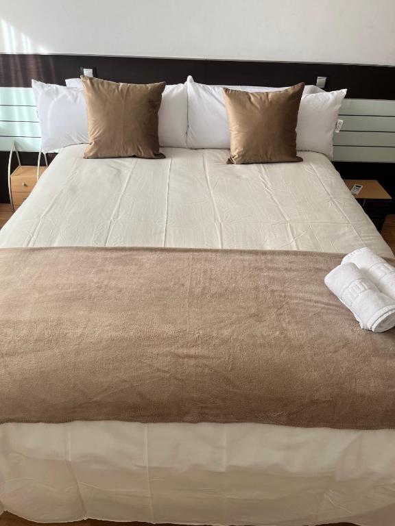 a large white bed with pillows on top of it at Apartamento en Zaragoza-3 in Zaragoza
