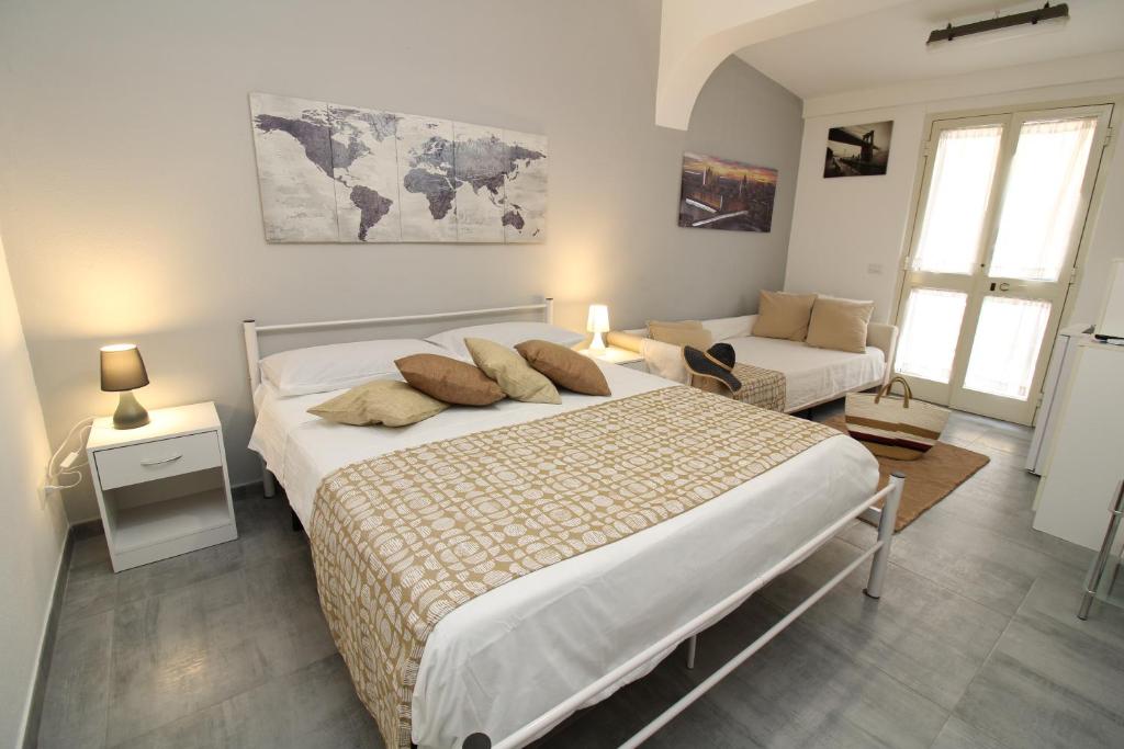 Un dormitorio con una cama grande y un sofá. en Summer Room- Fronte Spiaggia, en La Caletta