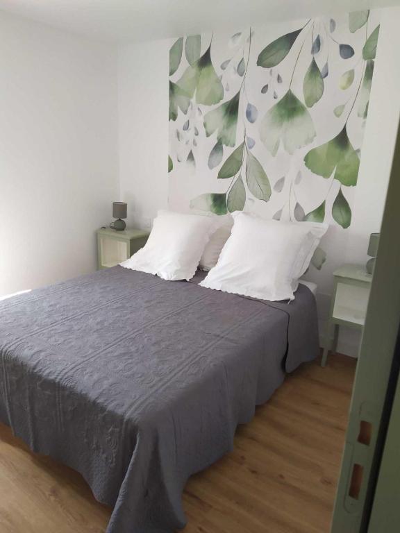 - une chambre avec un lit orné de motifs de feuilles sur le mur dans l'établissement Foyer Magistérien, à Porta