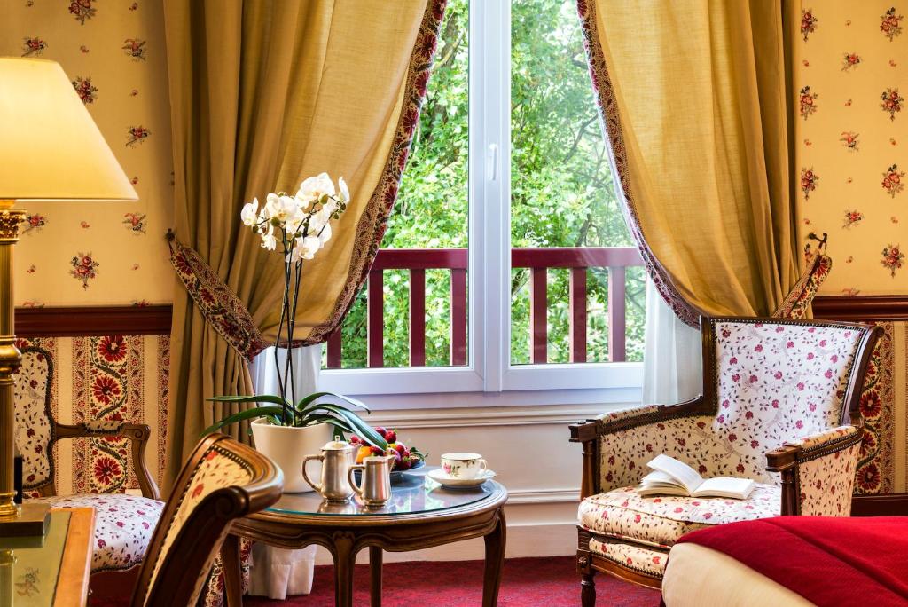 a room with a table and chairs and a window at Le Castel Marie Louise in La Baule