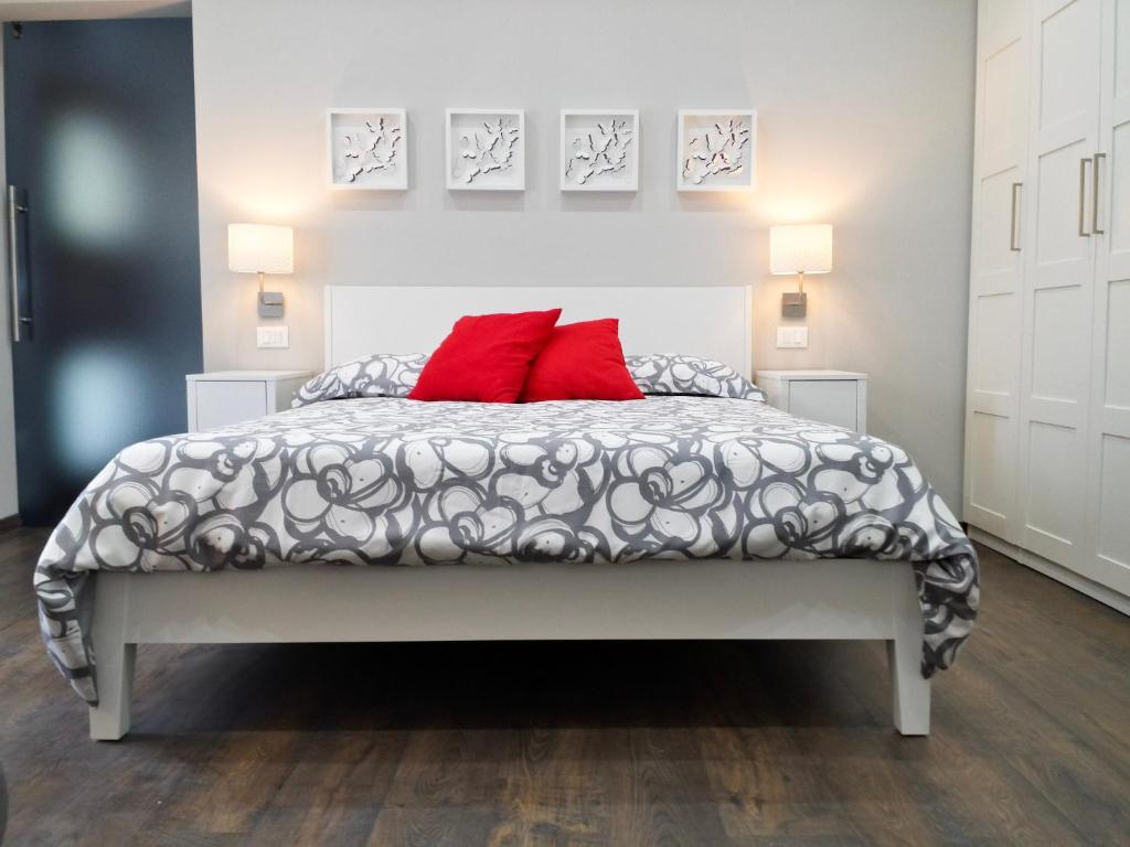 sypialnia z łóżkiem z 2 czerwonymi poduszkami w obiekcie Appartamento Elegante w mieście Cannero Riviera