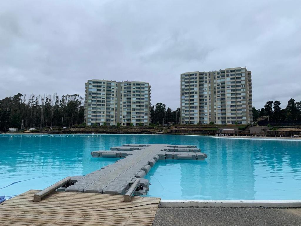 a large swimming pool with blue water and tall buildings at Hermoso Depto full equipado 2D y 2B vista al Mar, Laguna y Dunas in El Tabo