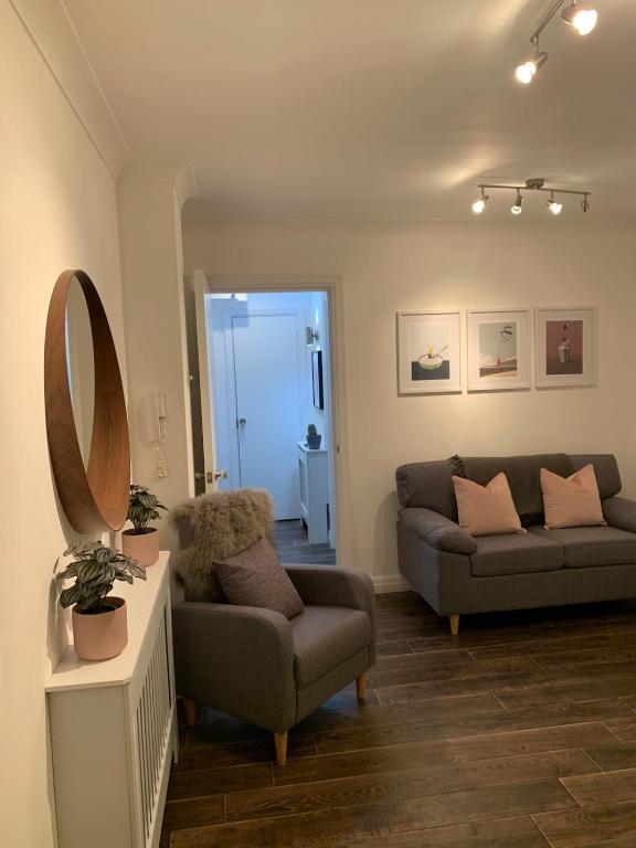 Hotel Best located Flat in Cheltenham and Free Parking, a living room with a couch and a mirror at Best located Flat in Cheltenham and Free Parking in Cheltenham