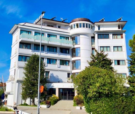 duży biały budynek z drzewami przed nim w obiekcie Hotel Napoleon w Lukce