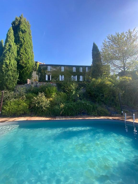 une piscine d'eau en face d'un bâtiment dans l'établissement Bastide 500m2 Bastide - Piscine, Vue Pyrénées à 180, à Latour