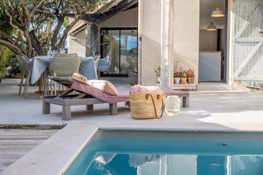 une terrasse avec une chaise et une piscine dans l'établissement Slow Villa, 5 chambres avec piscine, à Pérols