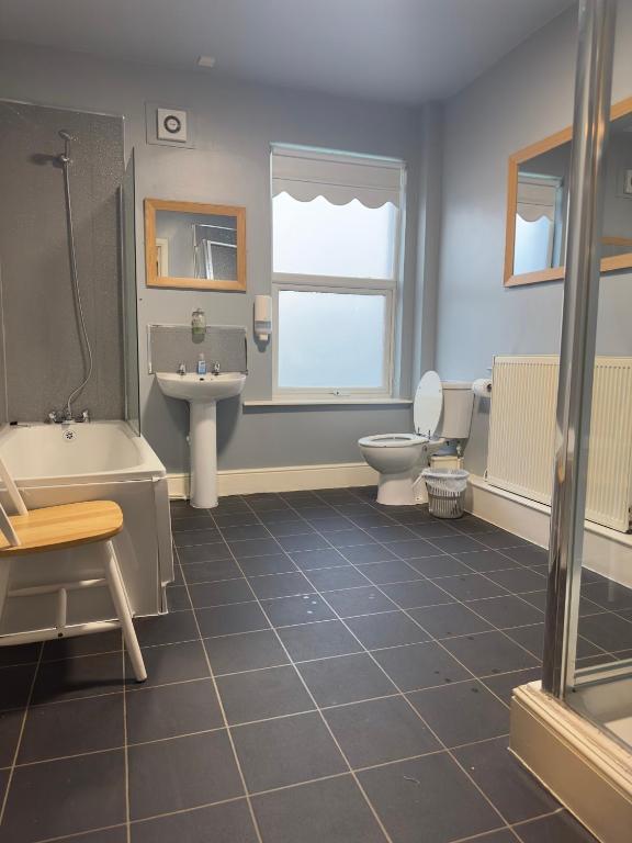 a bathroom with a tub and a toilet and a sink at The Prince Alfred Rooms in Liverpool