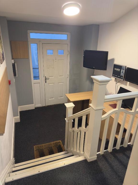 a room with a staircase with a door and a television at The Prince Alfred Rooms in Liverpool