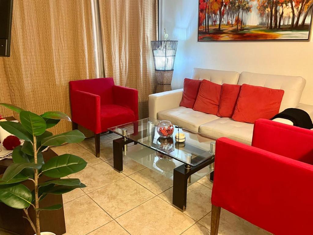 a living room with a couch and two red chairs at Departamento 2D en Iquique!!! in Iquique