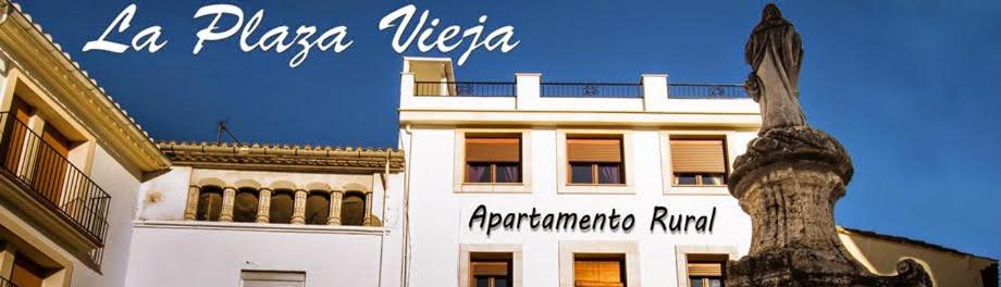 een wit gebouw met een palmboom ervoor bij Apartamento Rural La Plaza Vieja in Viver