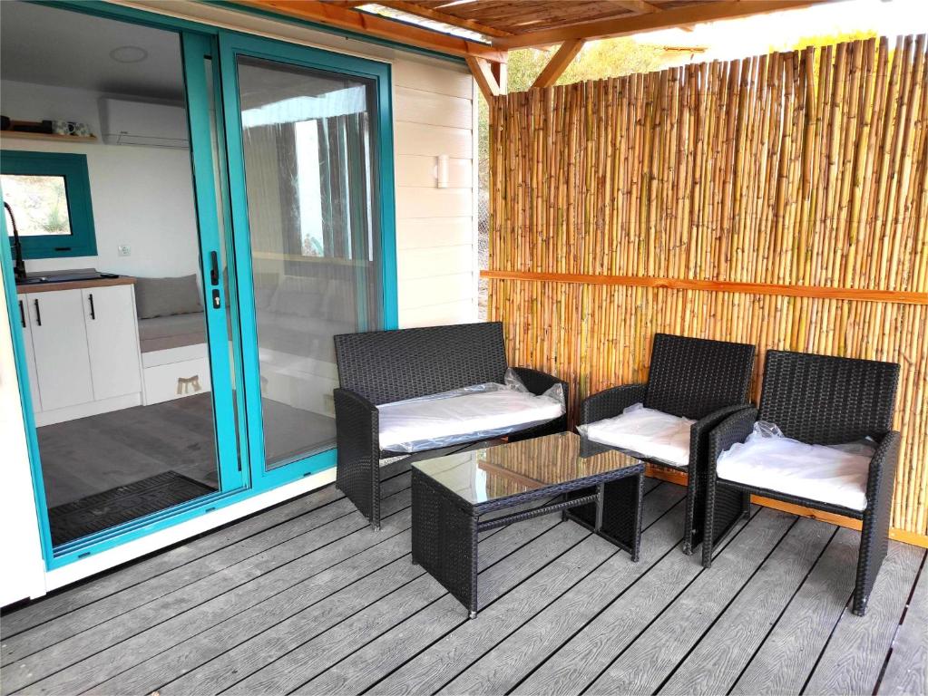 two chairs and a table on a screened porch at Tiny Haus Komos in Pitsidia