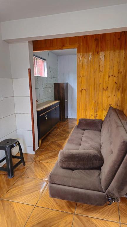 un grande divano marrone in una stanza con un tavolo di Studio Marangoni Hospedaria Apartamento 2 a Treze Tílias