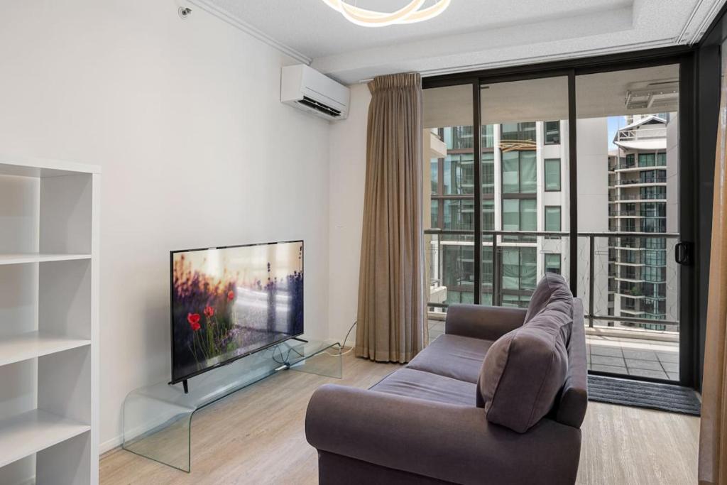 a living room with a couch and a flat screen tv at Best Value 2Beds Apt at CBD with Pool Gym Carpark in Brisbane